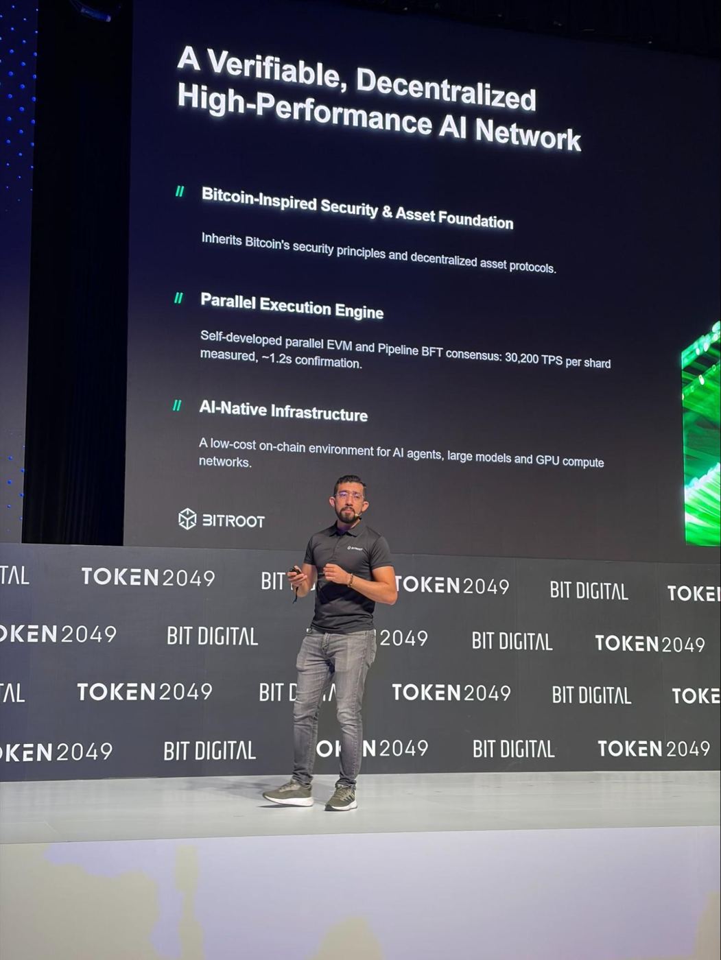 A Bitroot representative speaking on the TOKEN2049 Singapore main stage, with Bitroot's technical positioning shown on the large screen